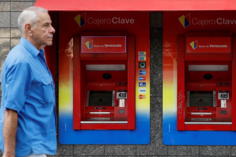 A man walks past automated teller machines (ATM) of Banco de Venezuela in Caracas