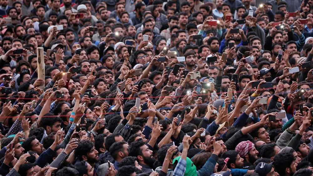 People use their mobile phones to take photographs of the body of Kashmiri professor Mohammad Rafi Bhat, a suspected militant, after he was killed in a gunbattle with Indian security forces in south K