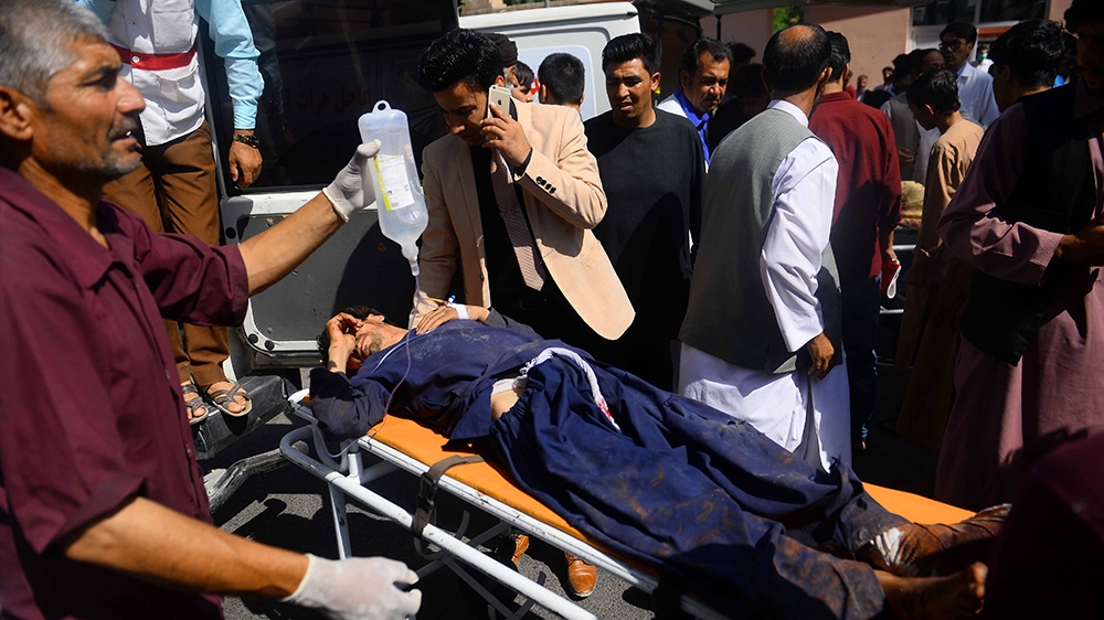 Graphic content / An injured Afghan man is transported on a stretcher after being injured when a bus hit a roadside bomb on the Kandahar-Herat highway, at a hospital in Herat on July 31, 2019. - Dozen
