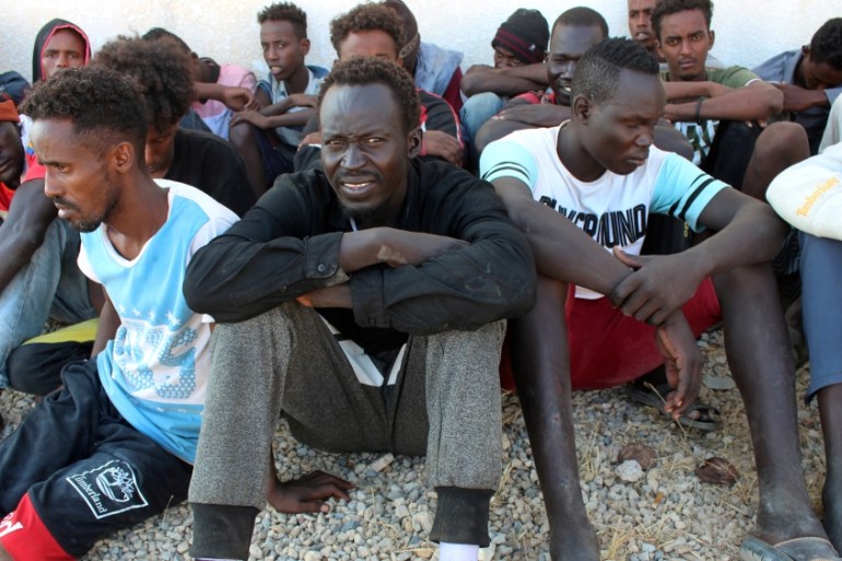 Migrants rescued by Libyan coast guard after their wooden boat capsized off the coast of Komas, look on as they sit in the town east of the capital Tripoli