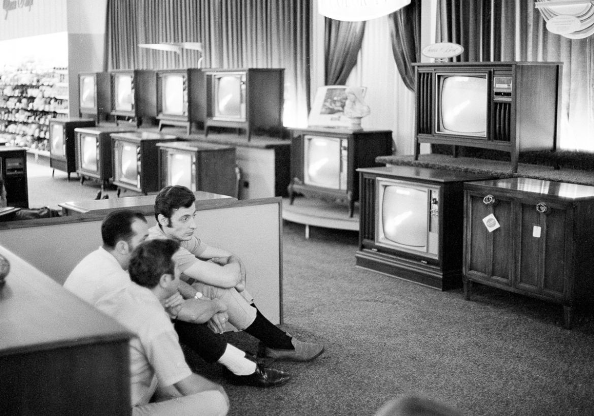 "People watch the Apollo 11 Saturn V rocket launch on multiple TV''s at a Sears department store in White Plains, New York on July 16, 1969. [File: Ron Frehm/AP Photo] "