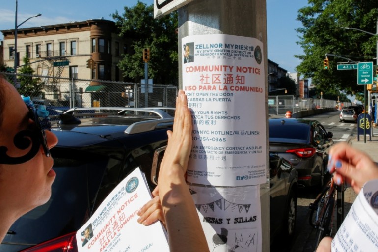 Community members place pamphlets while communities braced for a reported wave of deportation raids across the United States by Immigration and Customs Enforcement officers in Brooklyn, New York