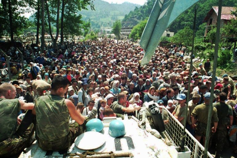 FILE This July 13, 1995 file photo shows Dutch UN peacekeepers sitting on top of an APC as Muslim refugees from Srebrenica, eastern Bosnia, gather in the village of Potocari,