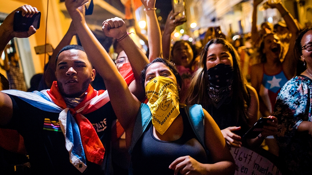 People celebrate outside the governor's mansion La Fortaleza, after Gov. Ricardo Rossello announced that he is resigning Aug. 2 after weeks of protests over leaked obscene, misogynistic online chats, 