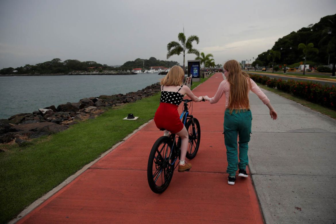 Aydili Gonzalez (R), 23, teaches her sister Ceily (L), 19, how to ride a bike, at the Causeway Islands in Panama City, Panama, 22 June 2019. The indigenous Guna people, one of seven ethnic groups in P