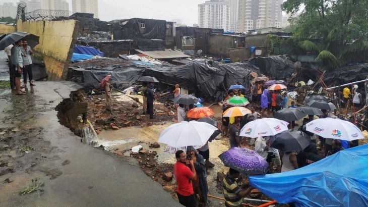 People stand among the debris after a wall collpased on hutments due to heavy rains in Mumbai, India July 2, 2019. REUTERS/Prashant Waydande