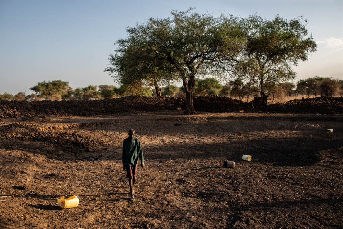 James Jongkuch Nyang, a 55-year-old pastoralist, walks through the empty Mabil water pond in Ruar Leek village, Bor county, Jonglei State, South Sudan, in April 5, 2019. Much of South Sudan suffers fr