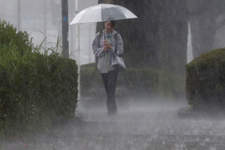 A pedestrian walks through heavy rain in Kirishima, Kagoshima Prefecture, southwestern Japan
