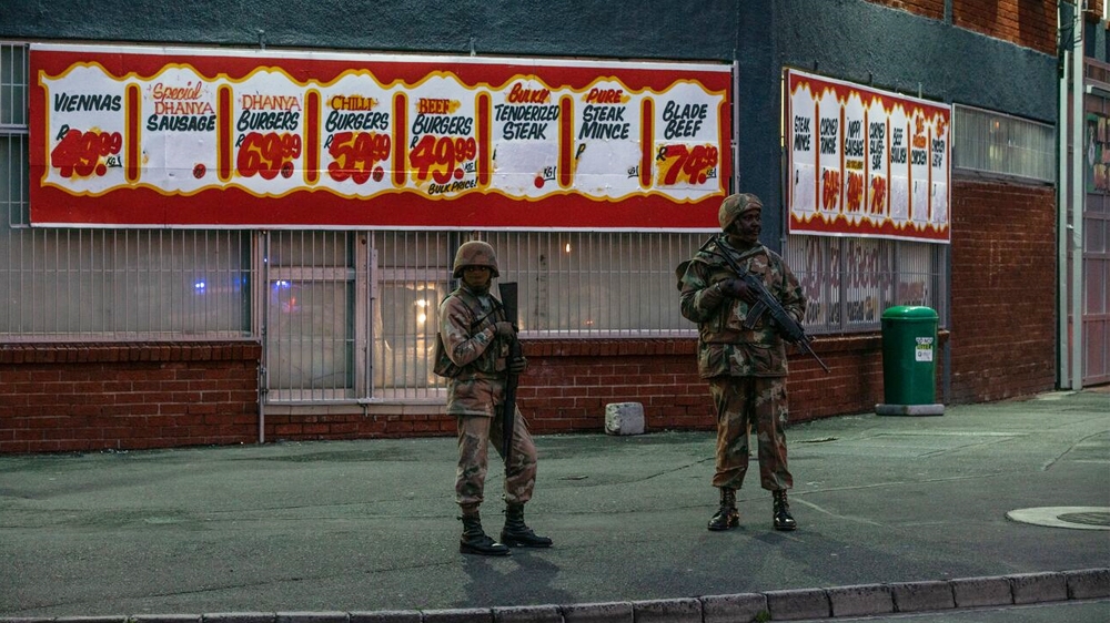 Soldiers stand in front of a shop  in Hanover Park, in a heavily gang-afflicted area on the Cape Flats [Shaun Swingler/Al Jazeera]