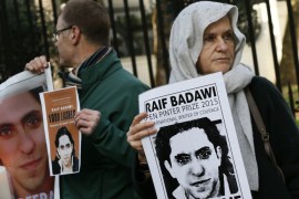 Demonstrators hold placards during a protest for Saudi blogger Raif Badawi, outside the Saudi embassy in London