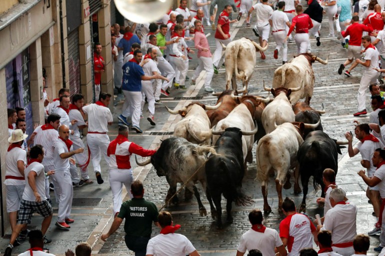 Revellers sprint near bulls and steers during the second running of the bulls at the San Fermin festival in Pamplona, July 8. REUTERS/Susana Vera