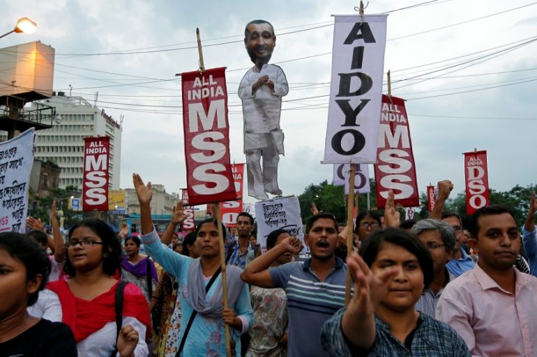People shout slogans as they carry an effigy depicting Kuldeep Singh Sengar, a legislator of the ruling BJP, during a protest demanding jus