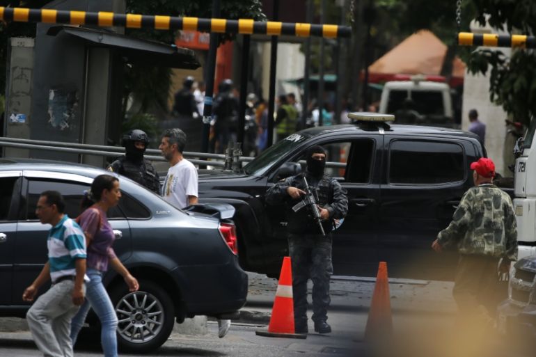 Masked agents of Venezuela’s police intelligence agency stand guard at the entrance of the opposition-controlled congress