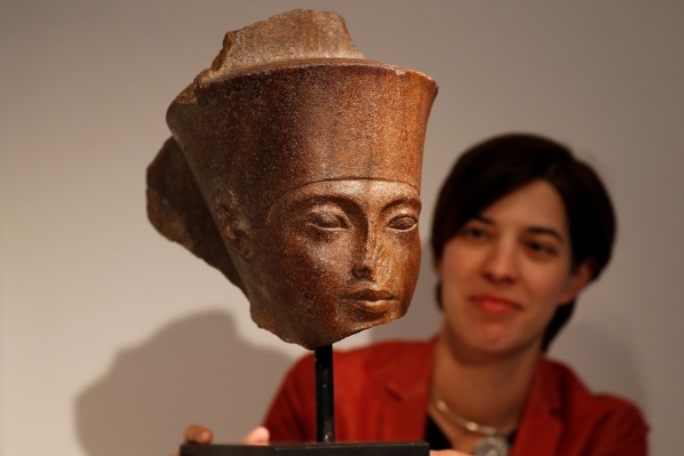 Laetitia Delaloye, head of antiquities of Christie''s, poses for a photograph with an Egyptian brown quartzite head of the God Amen prior to its'' sale at Christie''s auction house in London, Britain,