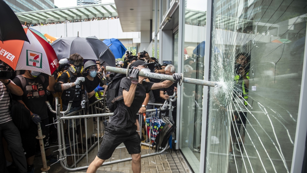 A protester is seen holding a steel pipe trying to break the glass outside Legco in Hong Kong, China. 1 July 2019. Hundreds of protesters gather outside trying to break the glass of Hong Kong's mini-
