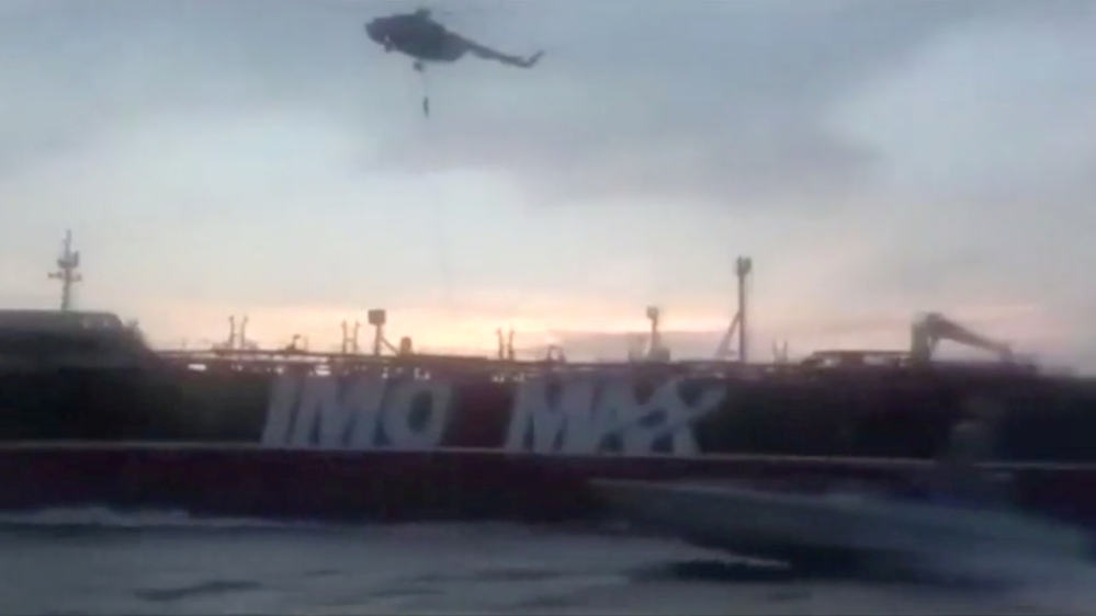An Iranian Revolutionary Guard troop member rapels to British-flagged tanker Stena Impero's deck from a helicopter near the strait of Hormuz