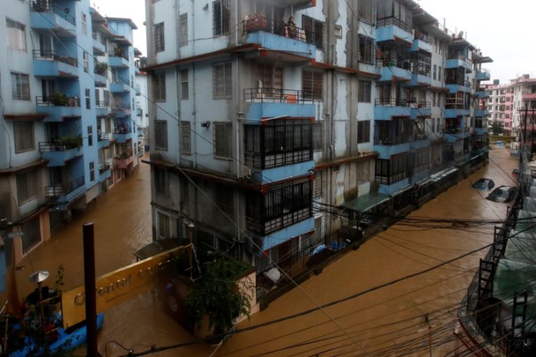 Residents look from a balcony to the flooded colony in Kathmandu
