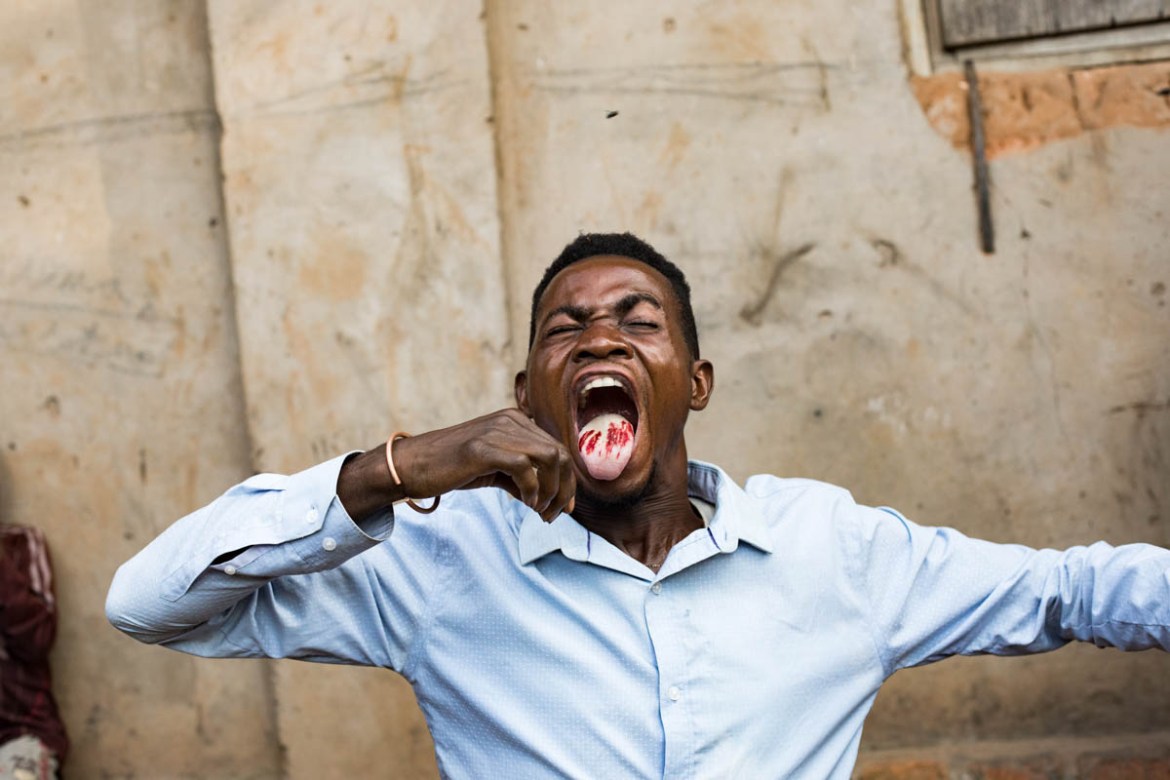 A Kamuina Nsapu militiaman in a trance cuts his tongue with a razor blade in the commune of Nganza. Strongly imbued with mysticism, the militiamen all believe that they are endowed with magical powers