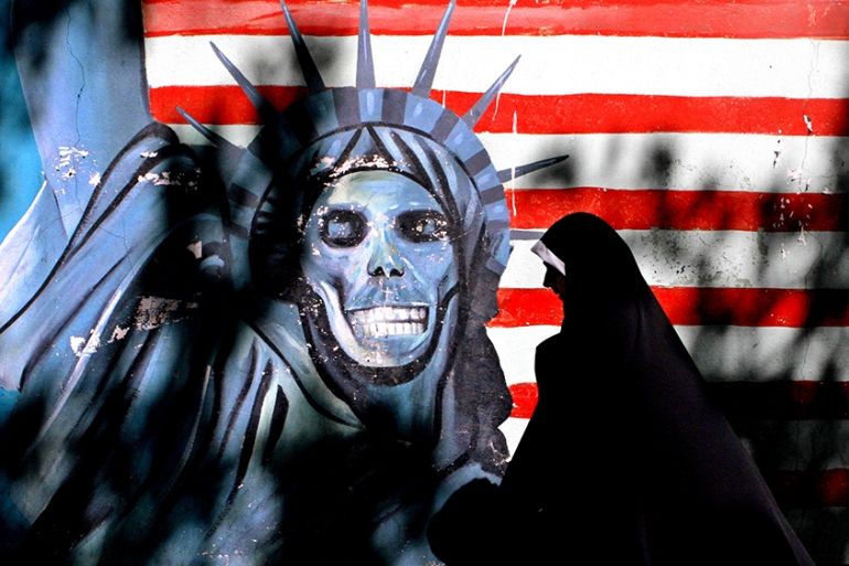FILE - In this Sept. 25, 2007, file photo, an Iranian woman walks past graffiti art characterizing the U.S. Statue of Liberty, painted on the wall of the former U.S. Embassy in Tehran, Iran. The famil