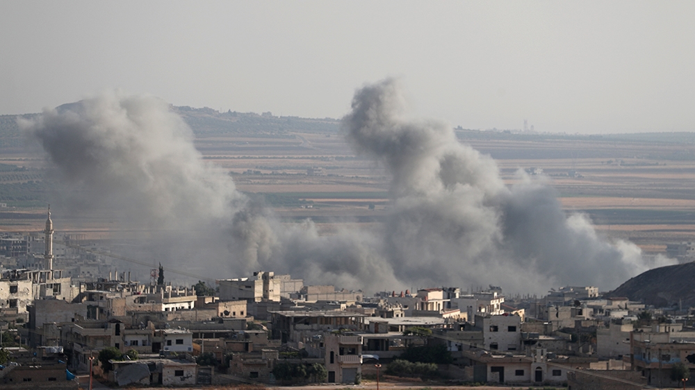 This picture taken on August 5, 2019 shows smoke billowing above buildings during a reported air strike by pro-regime forces on Khan Sheikhun in the south of the northwestern Syrian province of Idlib.