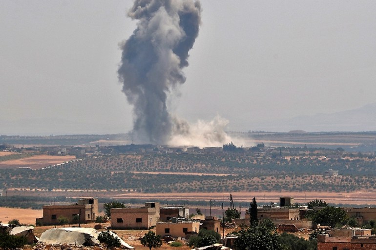 Smoke billows above buildings during a reported air strike by pro-regime forces on Khan Sheikhun in Syria''s Idlib province on August 19, 2019. - A Turkish military convoy crossed into northwest Syria