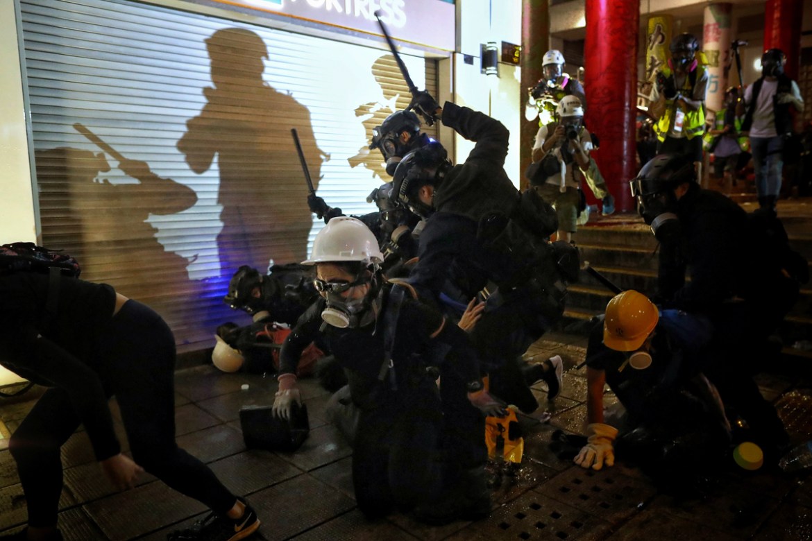 Policemen charge towards protesters during the anti-extradition bill protest at Tsim Sha Tsui in Hong Kong, Sunday, Aug. 11, 2019. Police fired tear gas late Sunday afternoon to try to disperse a demo