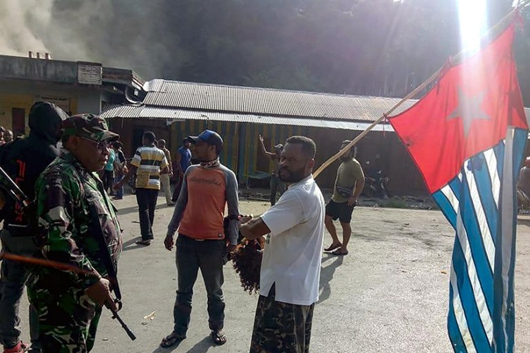 A protester carries the banned Papuan flag as he meets an Indonesian soldier in the city of Fakfak on August 21, 2019. - Indonesia''s Papua was hit by fresh unrest on August 21 as more than 1,000 secur