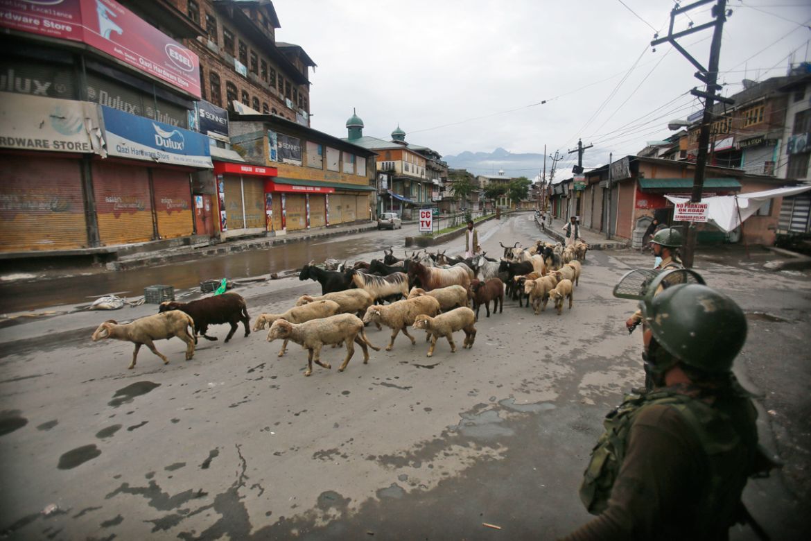 ndian paramilitary soldiers guard as a Kashmiri livestock seller crosses a street ahead of Eid al Adha during a security lock down in Srinagar, Indian controlled Kashmiri, Saturday, Aug. 10, 2019. Aut