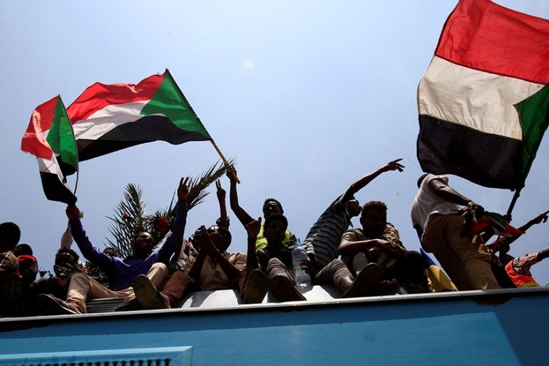 Sudanese civilians wave their national flags as they ride on the train to join in the celebrations of the signing of the Sudan''s power sharing deal, that paves the way for a transitional government, a