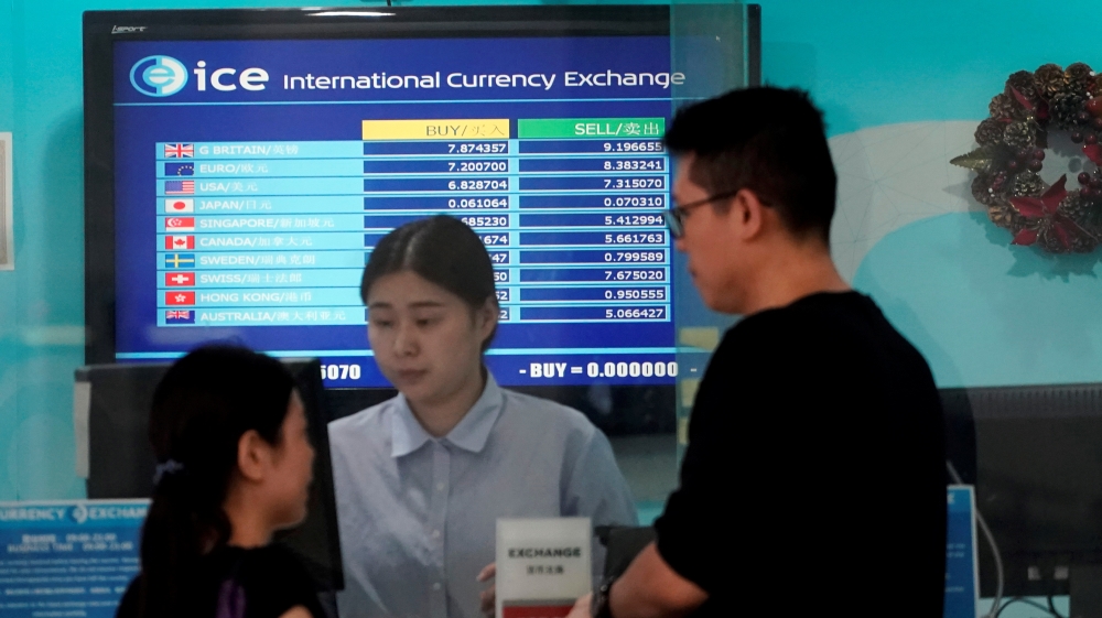 Customers are served at a counter at a currency exchange store in Shanghai