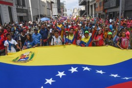 Pro-government protesters rally against US sanctions with a Venezuelan national flag in Caracas on August 7, 2019.