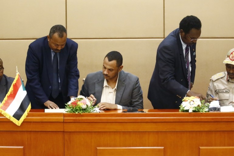 L to R) Ethiopian mediator Mahmoud Drir attends the signing of the constitutional declaration between protest leader Ahmad Rabie and General Mohamed Hamdan Daglo, Sudan''s deputy head of the Transition