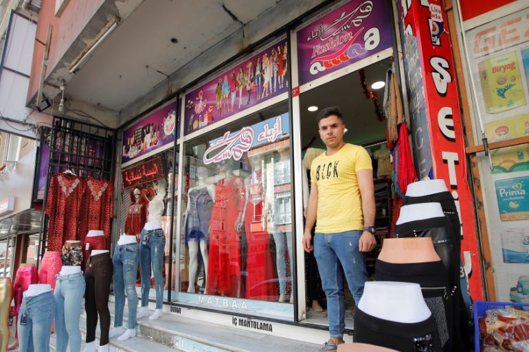 Syrian shopkeeper Mustafa poses in front of his clothes shop in Istanbul''s Kucukcekmece district