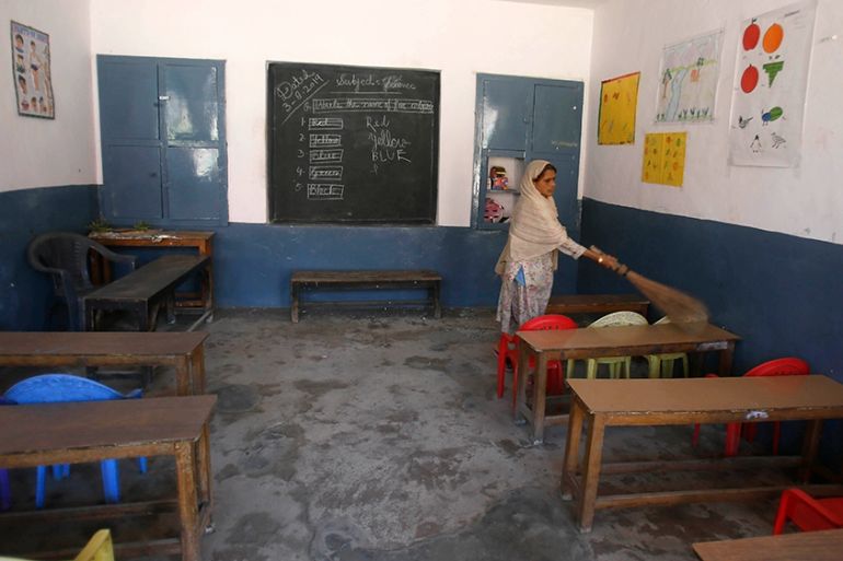 Kashmiri school staff member clean the empty class in a school in Srinagar, Indian, Monday, Aug. 19, 2019. (AP Photo/Mukhtar Khan)