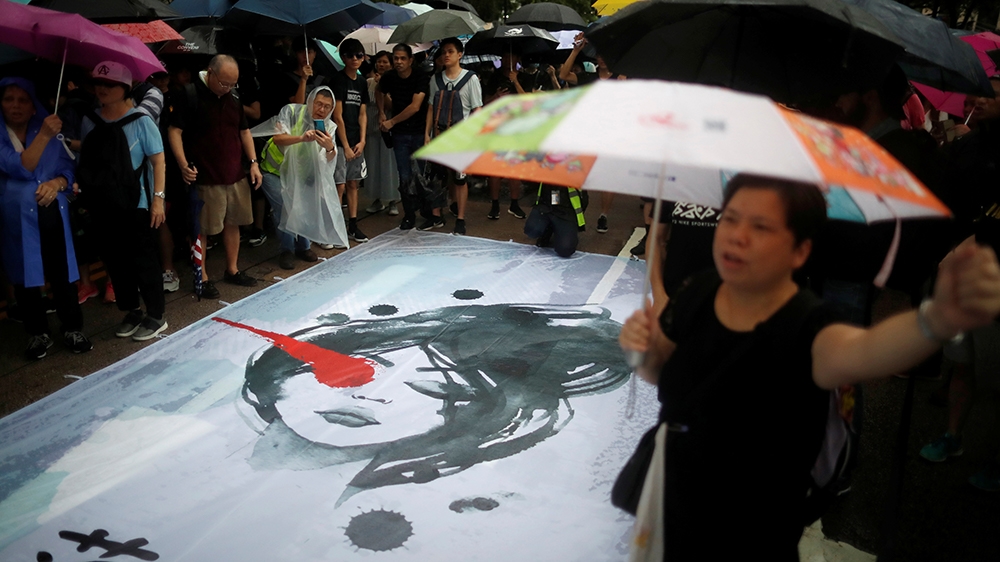 Anti-extradition bill protesters demonstrate next to a banner depicting a woman with an injured right eye during a rally to demand democracy and political reforms in Hong Kong, China, August 18, 2019.