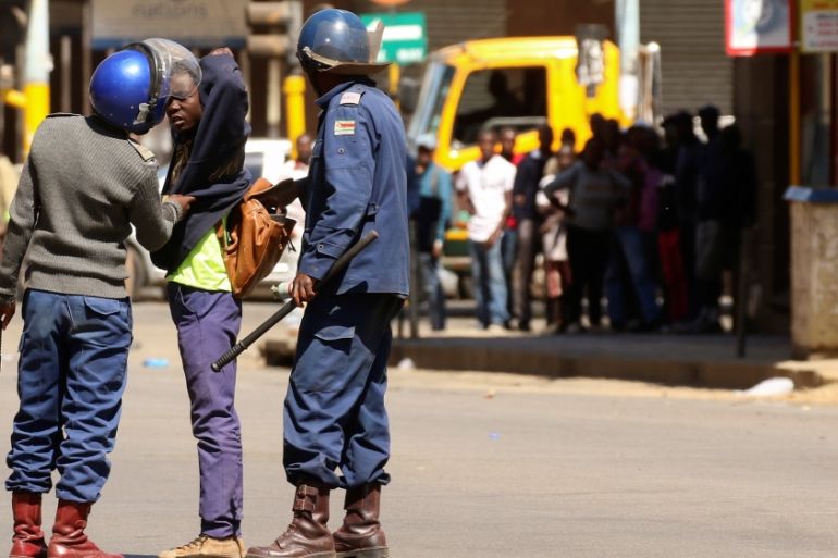 Riot police detain a protester during clashes after police banned planned protests over austerity and rising living costs called by the opposition Movement for Democratic Change (MDC) party in Harare