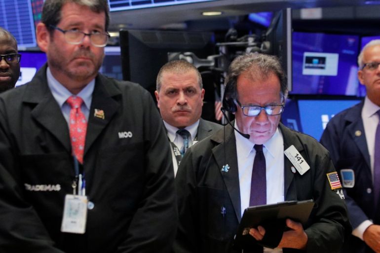 Traders pause for a moment of silence for victims of recent gun violence on the floor at the NYSE in New York