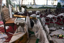 Afghan men investigate in a wedding hall after a deadly bomb blast in Kabul on August 18, 2019. - More than 60 people were killed and scores wounded in an explosion targeting a wedding in the Afghan c
