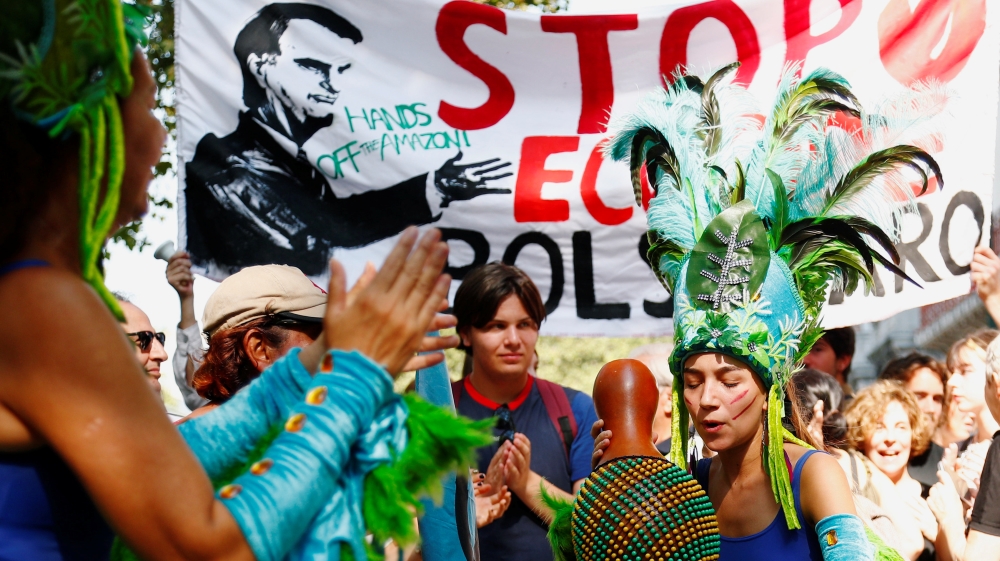 Protesters dance during a demonstration to demand protection for the Amazon rainforest outside the embassy of Brazil in Brussels