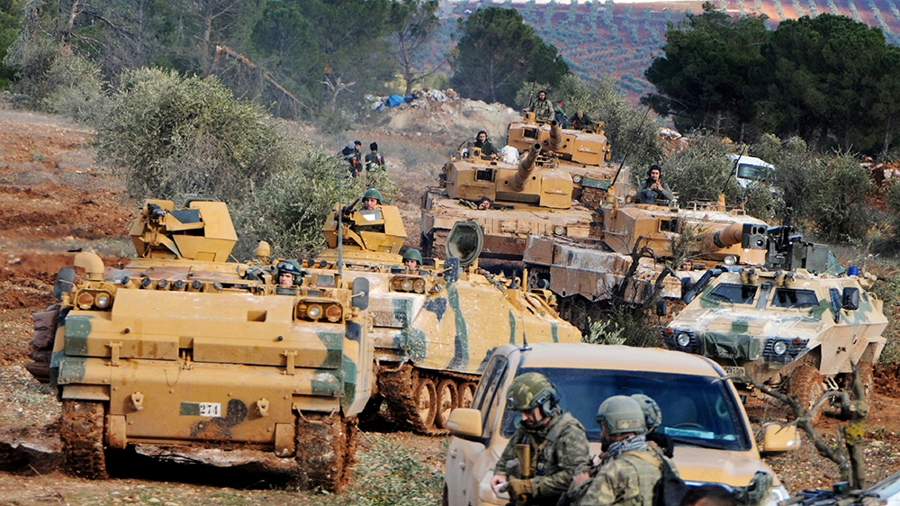 In this Jan. 28, 2018, file photo, Turkish troops take control of Bursayah hill, which separates the Kurdish-held enclave of Afrin from the Turkey-controlled town of Azaz, Syria. The violence raging o
