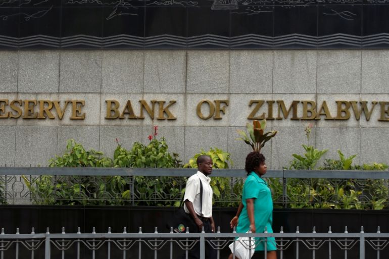 People walk past the Reserve Bank of Zimbabwe building in Harare