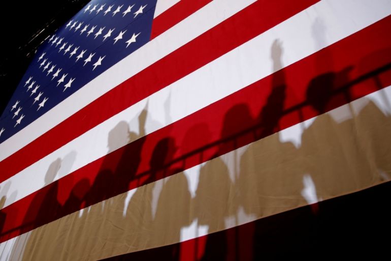 The shadows of supporters of U.S. President Donald Trump are seen on an American Flag at a campaign rally in Las Vegas