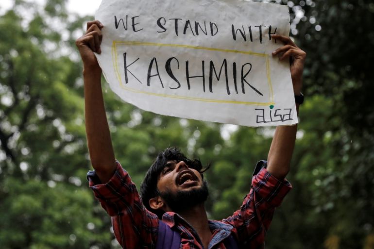 A man holds a sign and shouts slogans during a protest after the government scrapped the special status for Kashmir, in New Delhi