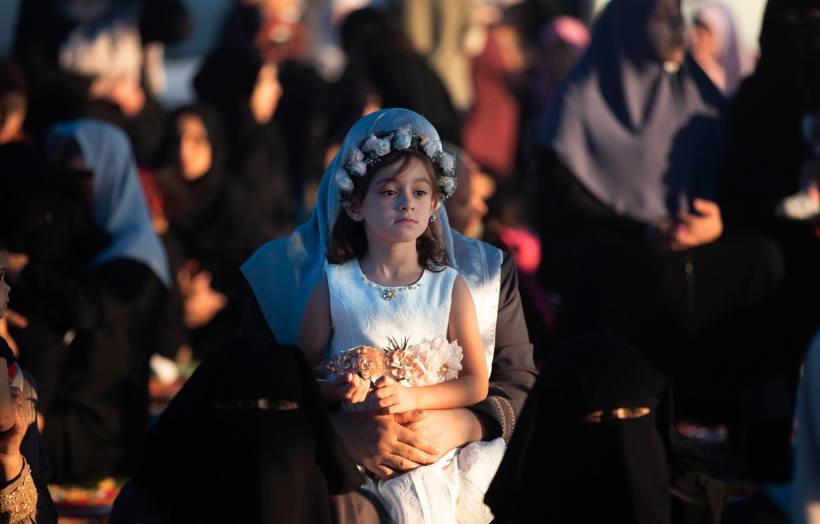 A Palestinian girl dressed up as she attends prayers to mark the first day of Eid al-Adha, in Gaza City, Sunday, Aug. 11, 2019. During the Eid al-Adha, or Feast of Sacrifice, Muslims slaughter sheep o