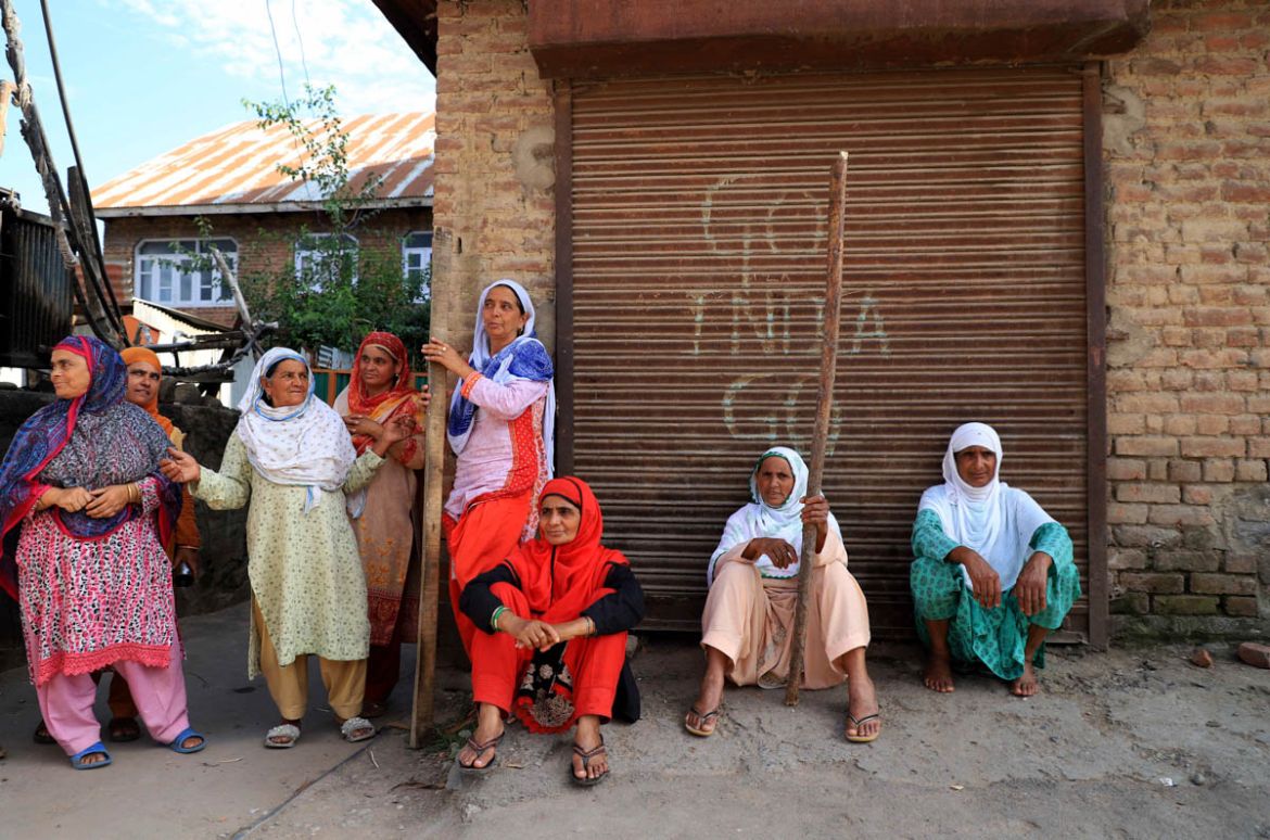 Women holding wooden sticks sit on a street in during clashes with forces in  Anchaarsoura Srinagar on August 23, Jalla begum (middle) says we are here to protect our boys they are our honor  ,the for