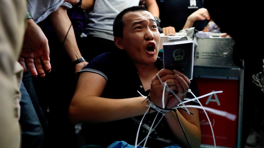 Fu Guohao, reporter of Chinese media Global Times website, is tied by protesters during a mass demonstration at the Hong Kong international airport, in Hong Kong