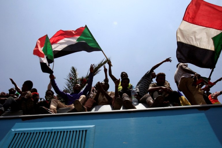 Sudanese civilians wave their national flags as they ride on the train to join in the celebrations of the signing of the Sudan''s power sharing deal, in Khartoum