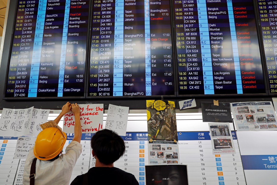 An information screen showing cancelled flights is pictured at Hong Kong International Airport as anti-extradition bill protesters attend a mass demonstration after a woman was shot in the eye during