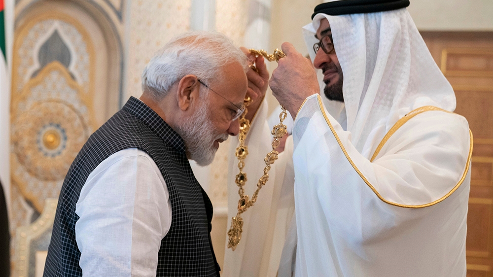 In this photograph made available by the state-run WAM news agency, Indian Prime Minister Narendra Modi, left, receives a medal during his induction to the Order of Zayed from Sheikh Mohammed bin Zaye