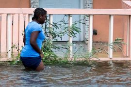 woman walks in a flooded street after the effects of Hurricane Dorian arrived in Nassau, Bahamas, September 2, 2019. REUTERS/John Marc